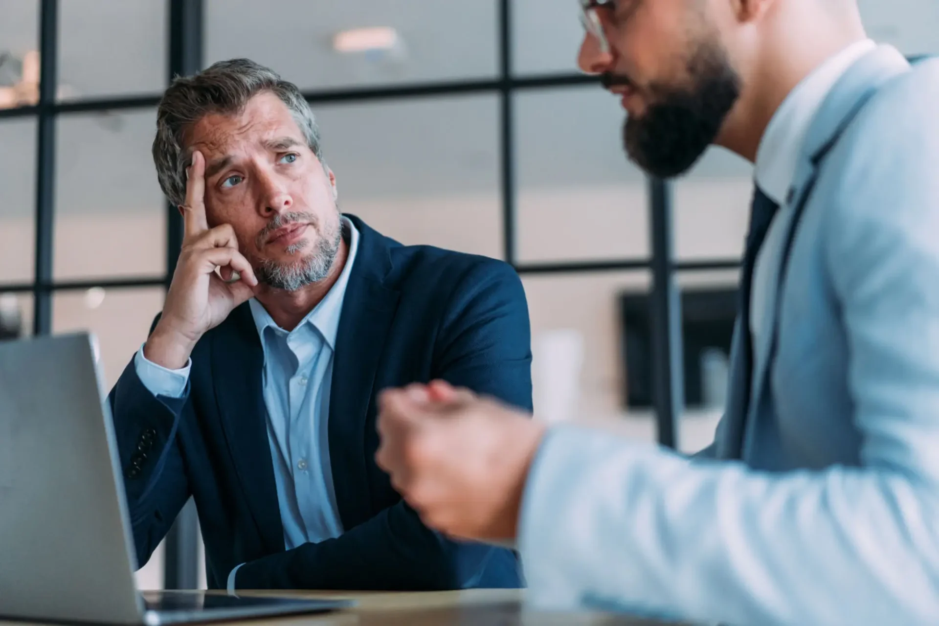 Concerned businessman listening to colleague during meeting